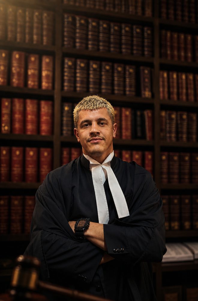 Joseph, The JD Tutor, in legal robes in a law library